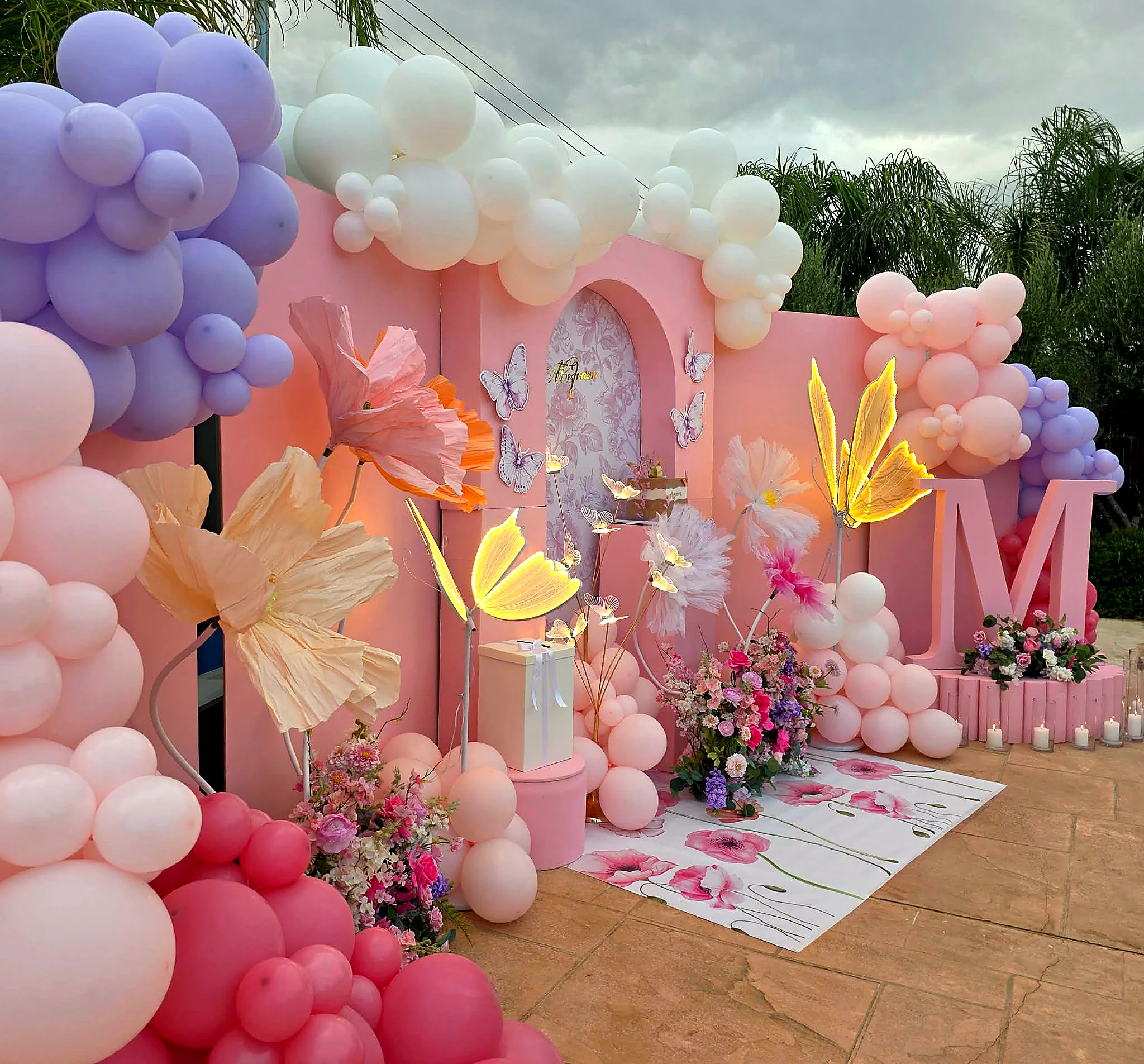 Close view of a pastel butterfly and balloon backdrop built for a christening